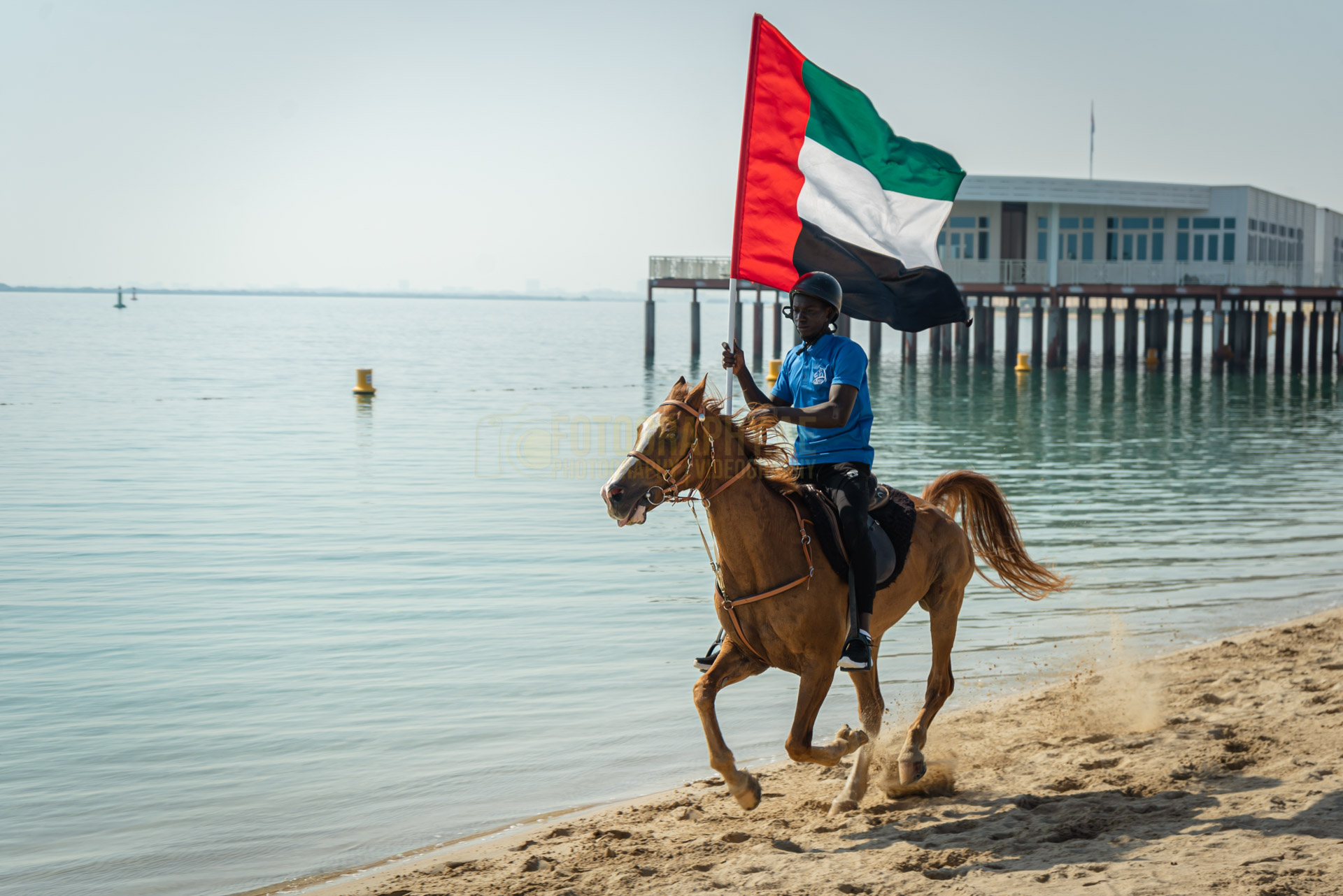 professional image of a rider, riding a horse with a UAE flag