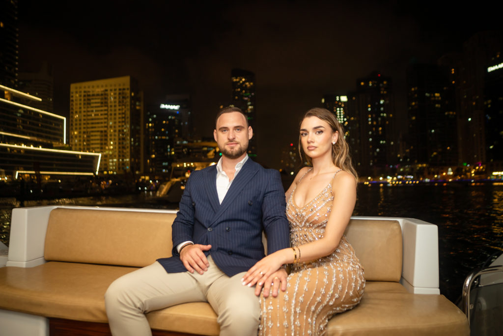 Professional Photograph of a couple posing on a yacht overseeing the dubai Marina.