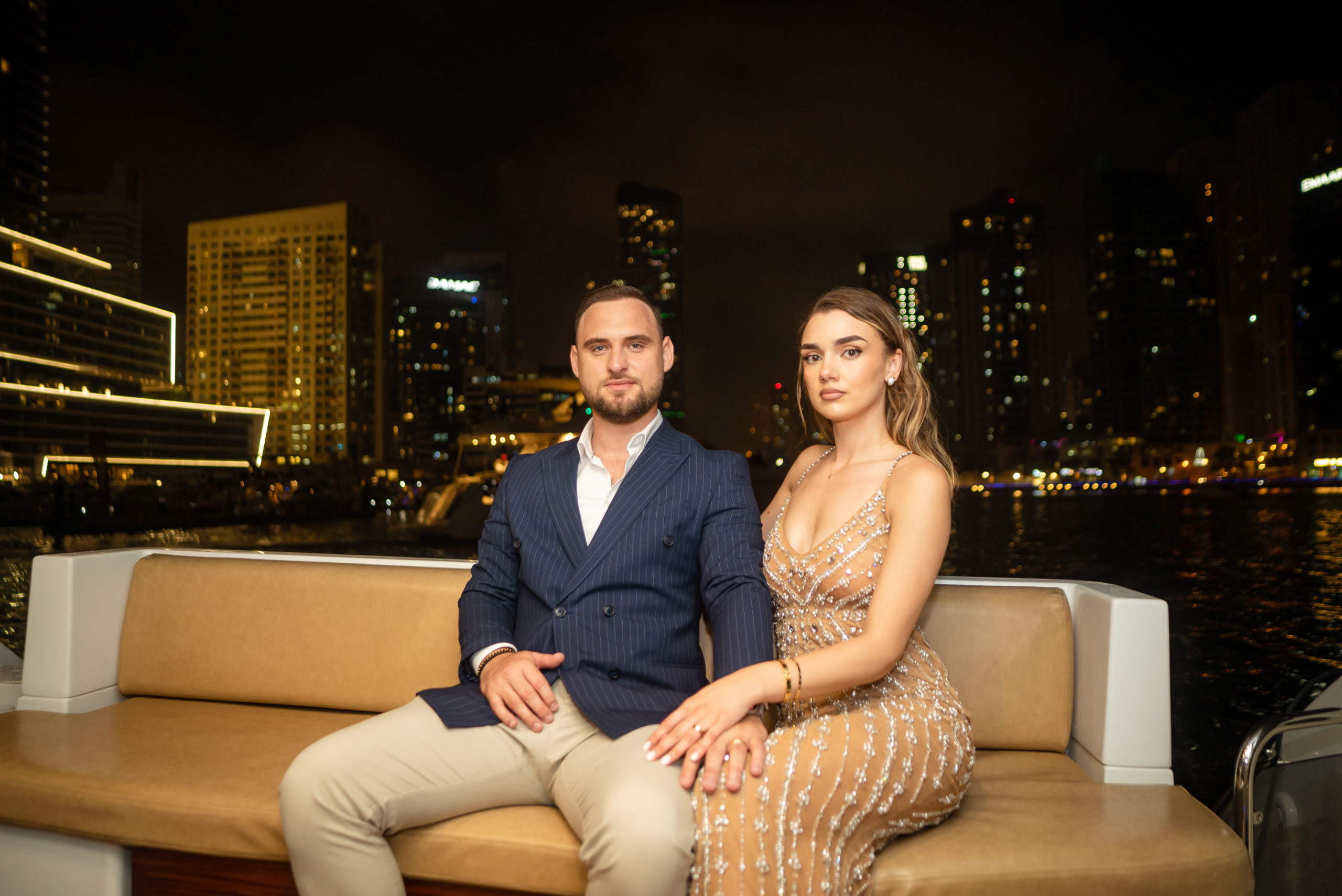 Professional Photograph of a couple posing on a yacht overseeing the dubai Marina.
